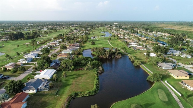 drone / aerial view with golf course view, a water view, and a residential view