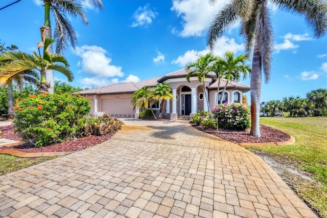 14810 Ingraham Blvd, Port Charlotte, FL 33981 - mediterranean / spanish house featuring decorative driveway, a garage, stucco siding, a tile roof, and a front yard