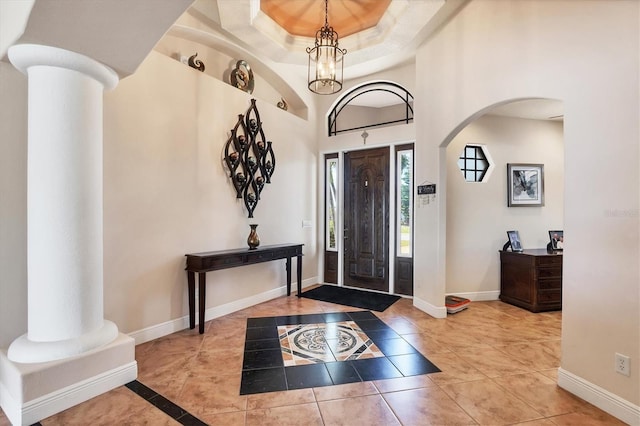 14810 Ingraham Blvd, Port Charlotte, FL 33981 - foyer entrance featuring arched walkways, baseboards, inlaid floor details, a tray ceiling, and a chandelier