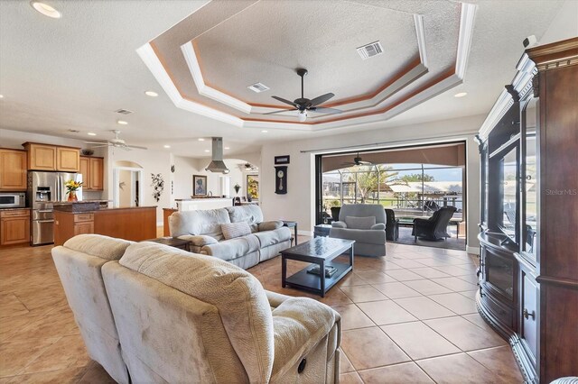 14810 Ingraham Blvd, Port Charlotte, FL 33981 - living room featuring ceiling fan, a raised ceiling, a textured ceiling, light tile patterned floors, and recessed lighting