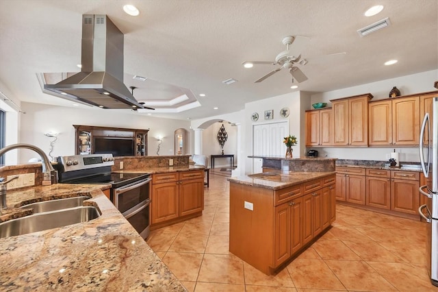 14810 Ingraham Blvd, Port Charlotte, FL 33981 - kitchen featuring appliances with stainless steel finishes, a sink, ceiling fan, arched walkways, and a center island