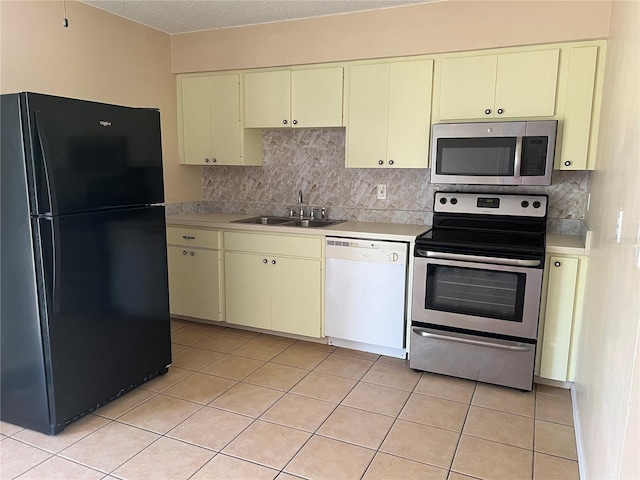 kitchen featuring a sink, stainless steel appliances, and cream cabinetry