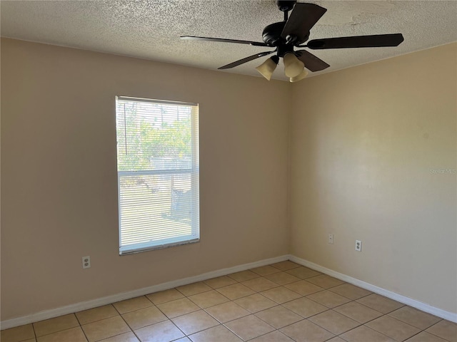 empty room featuring a ceiling fan, light tile patterned floors, and a healthy amount of sunlight