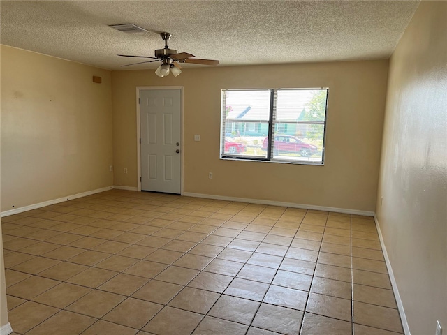 spare room featuring light tile patterned floors, ceiling fan, a textured ceiling, and visible vents