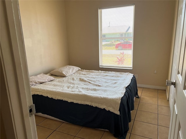 bedroom with baseboards and light tile patterned flooring