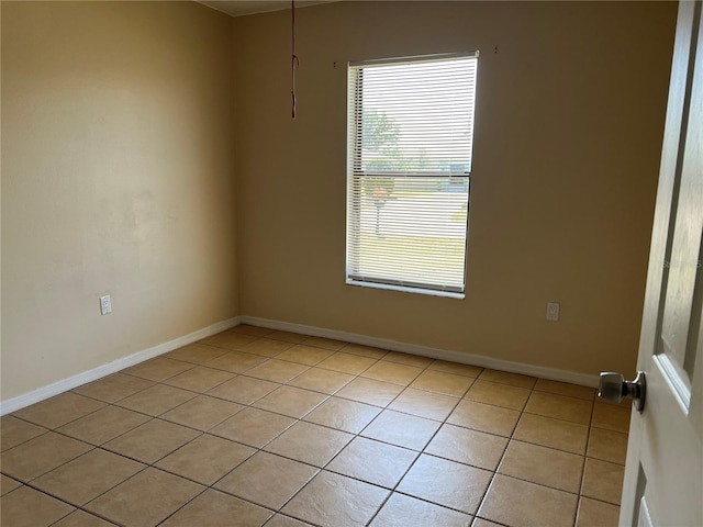 unfurnished room with light tile patterned floors and baseboards