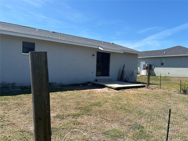 back of house featuring a lawn, fence, a patio area, and stucco siding