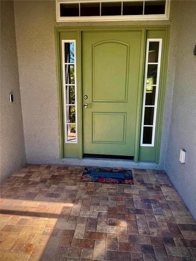 doorway to property featuring stucco siding