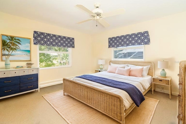 carpeted bedroom featuring baseboards and ceiling fan