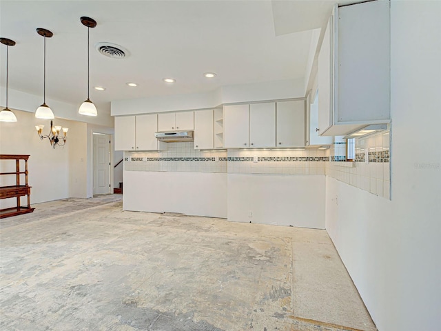 kitchen with a notable chandelier, white cabinetry, under cabinet range hood, decorative light fixtures, and visible vents