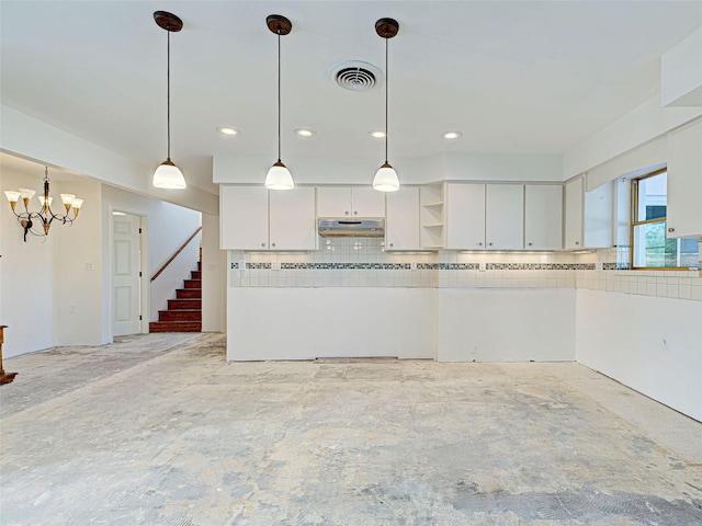 kitchen with white cabinets, tasteful backsplash, under cabinet range hood, and visible vents