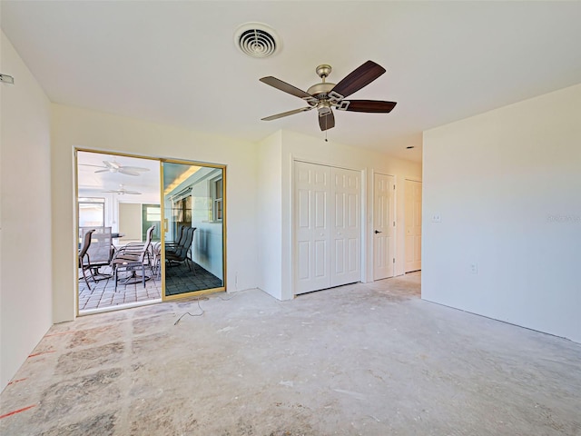 interior space featuring unfinished concrete flooring, a ceiling fan, visible vents, and multiple closets