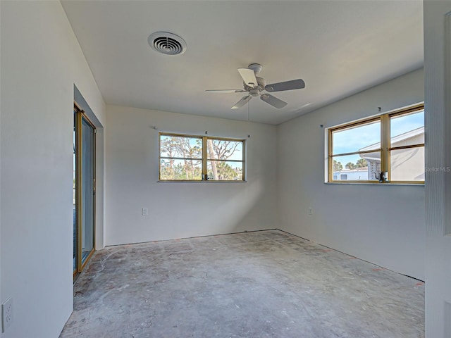 spare room with concrete flooring, visible vents, and a ceiling fan
