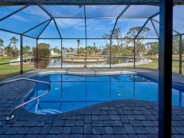 pool featuring a lanai, a patio area, and a water view