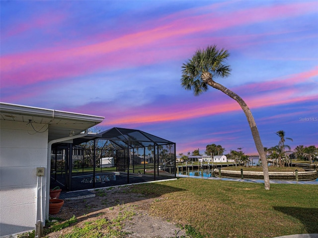 view of yard featuring a water view, an outdoor pool, and a lanai