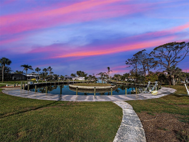 dock area with a yard and a water view