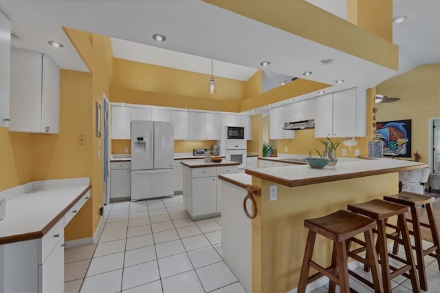 850 Van Gogh Rd, Englewood, FL 34223 - kitchen with white appliances, a peninsula, under cabinet range hood, light tile patterned flooring, and white cabinets