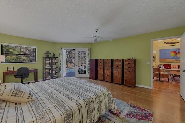 850 Van Gogh Rd, Englewood, FL 34223 - bedroom with multiple windows, a textured ceiling, wood finished floors, access to exterior, and ceiling fan