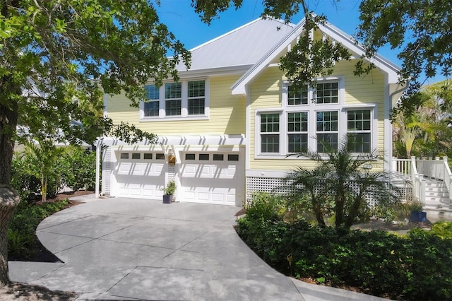 view of front of house with concrete driveway, stairs, and a garage