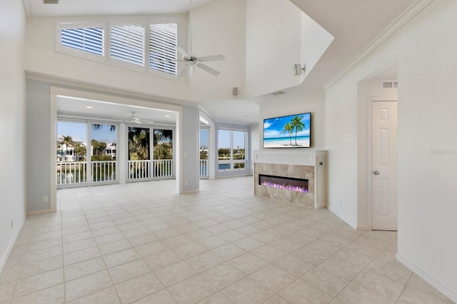 768 Seaboard Line Ln, Boca Grande, FL 33921 - unfurnished living room with ceiling fan, a glass covered fireplace, plenty of natural light, baseboards, and crown molding