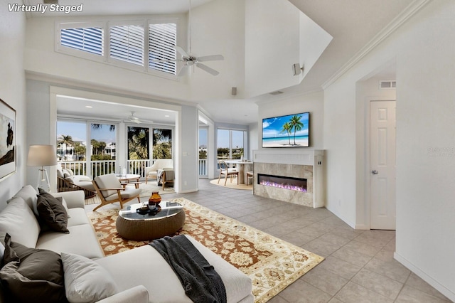 768 Seaboard Line Ln, Boca Grande, FL 33921 - living room with ceiling fan, baseboards, a high end fireplace, tile patterned floors, and a towering ceiling