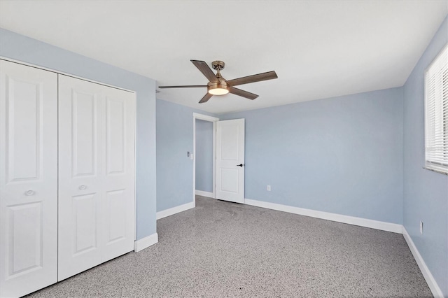 unfurnished bedroom with a ceiling fan, baseboards, a closet, and light speckled floor