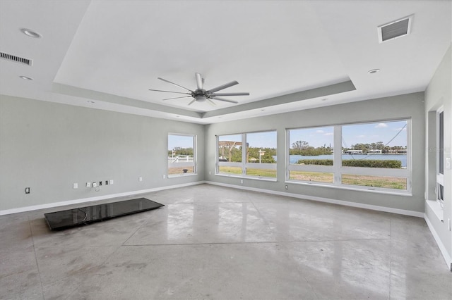 spare room featuring baseboards, visible vents, and a raised ceiling