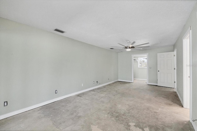 unfurnished room with unfinished concrete flooring, a ceiling fan, a textured ceiling, baseboards, and visible vents