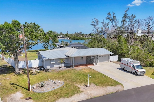 single story home featuring driveway, a water view, an attached garage, fence, and a front yard