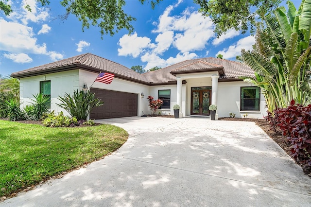 5 Saint John Blvd, Englewood, FL 34223 - mediterranean / spanish home with french doors, a tiled roof, a garage, concrete driveway, and stucco siding