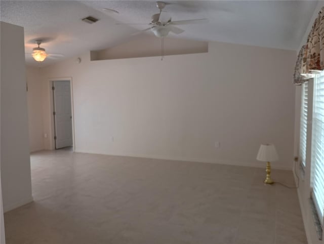 unfurnished room with a ceiling fan, visible vents, and vaulted ceiling