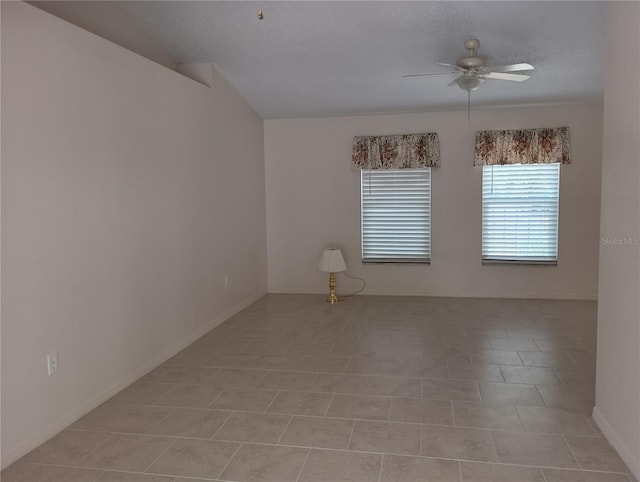 empty room featuring baseboards, ceiling fan, and light tile patterned floors
