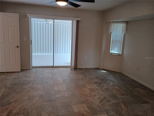 empty room with a ceiling fan and baseboards