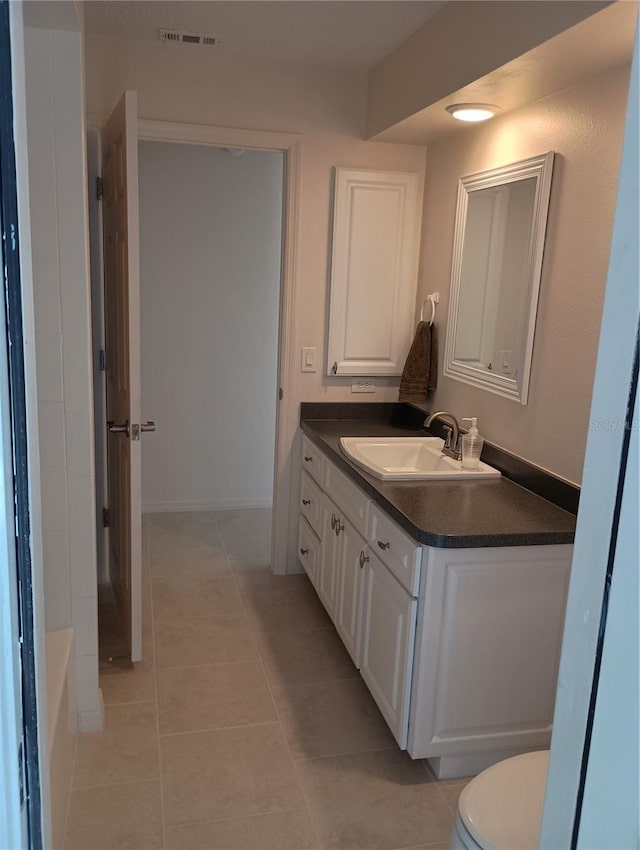 full bath with tile patterned floors, vanity, a bathtub, toilet, and visible vents