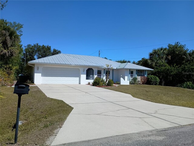 ranch-style home featuring stucco siding, an attached garage, driveway, and a front lawn