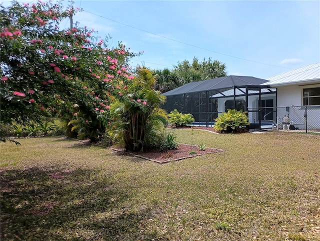 view of yard with fence and glass enclosure