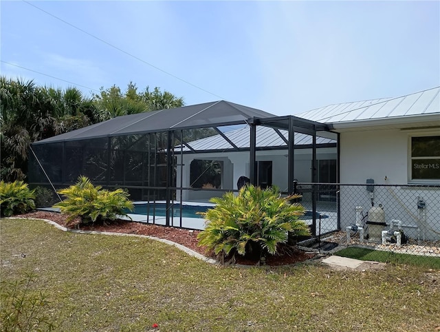 exterior space with fence, an outdoor pool, and glass enclosure