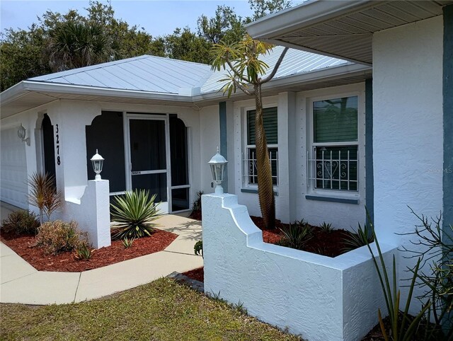 property entrance featuring an attached garage and stucco siding