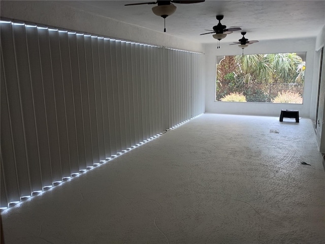 carpeted empty room featuring a ceiling fan