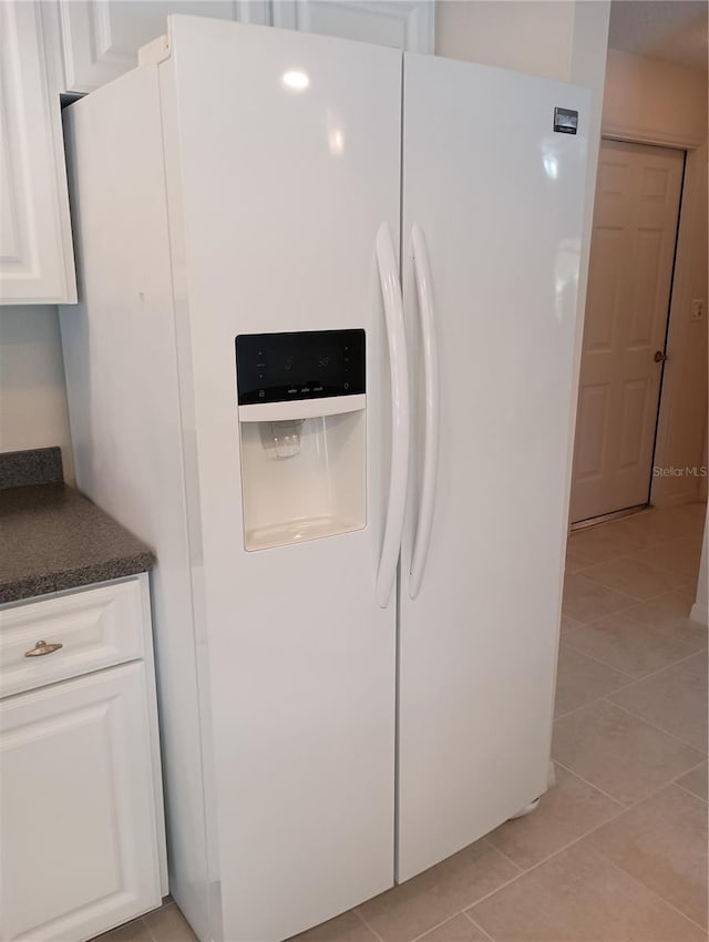 details featuring white cabinets, dark countertops, and white fridge with ice dispenser
