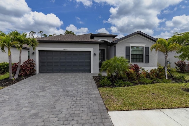 15968 Honeysuckle St, Port Charlotte, FL 33953 - single story home with stucco siding, an attached garage, decorative driveway, and a front yard