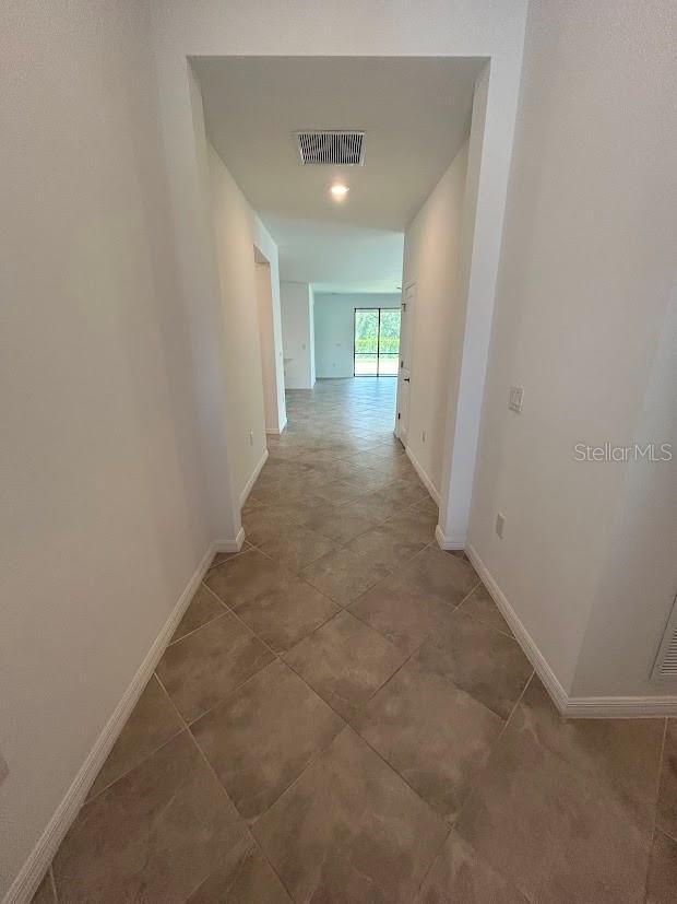 15968 Honeysuckle St, Port Charlotte, FL 33953 - hallway featuring baseboards and tile patterned floors