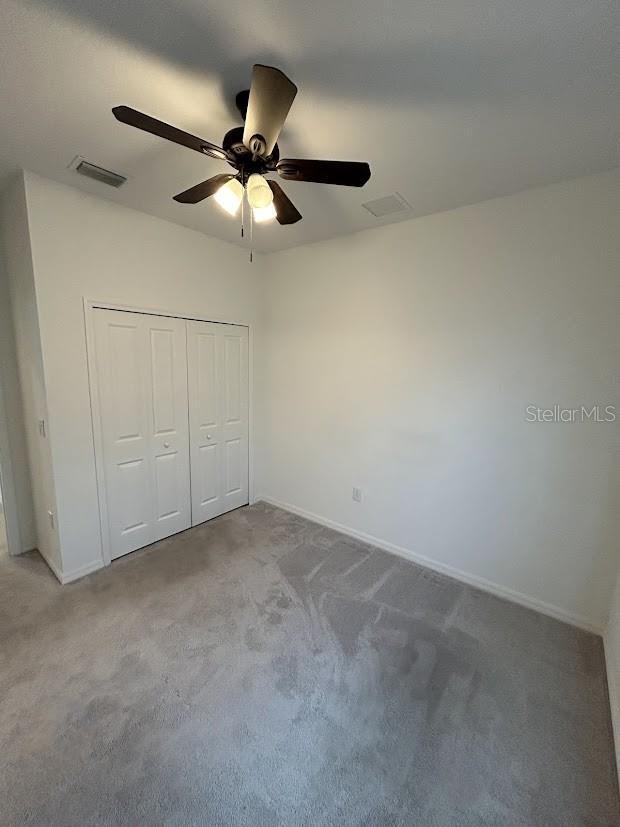 15968 Honeysuckle St, Port Charlotte, FL 33953 - unfurnished bedroom with carpet floors, baseboards, a closet, and a ceiling fan