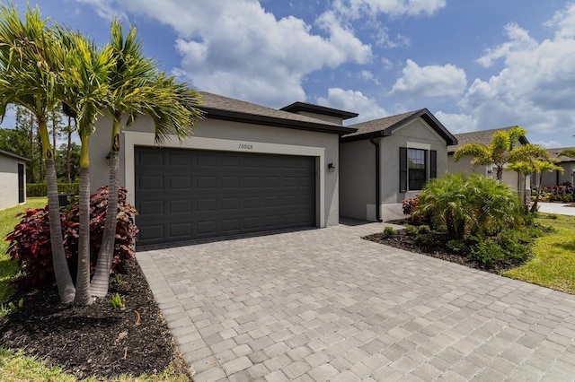 15968 Honeysuckle St, Port Charlotte, FL 33953 - single story home featuring stucco siding, decorative driveway, and a garage