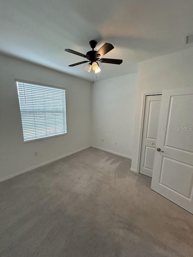 15968 Honeysuckle St, Port Charlotte, FL 33953 - spare room with a ceiling fan, carpet floors, and baseboards