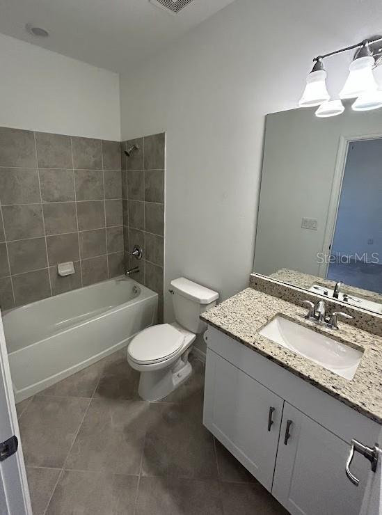 15968 Honeysuckle St, Port Charlotte, FL 33953 - full bathroom featuring tile patterned flooring, toilet, vanity, and shower / washtub combination