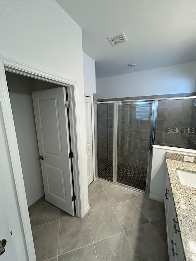 15968 Honeysuckle St, Port Charlotte, FL 33953 - bathroom featuring tile patterned floors, a shower stall, vanity, and baseboards