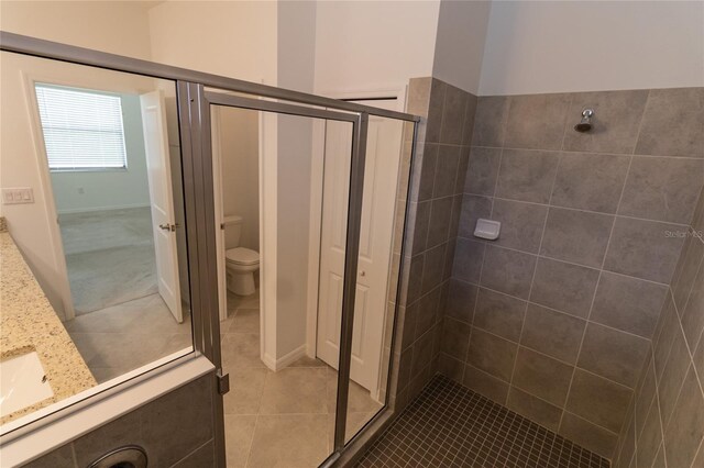 15968 Honeysuckle St, Port Charlotte, FL 33953 - bathroom with a shower stall, tile patterned flooring, vanity, and toilet