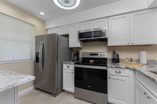 1551 Beach Rd Unit 412, Englewood, FL 34223 - kitchen featuring light wood finished floors, white cabinetry, and stainless steel appliances