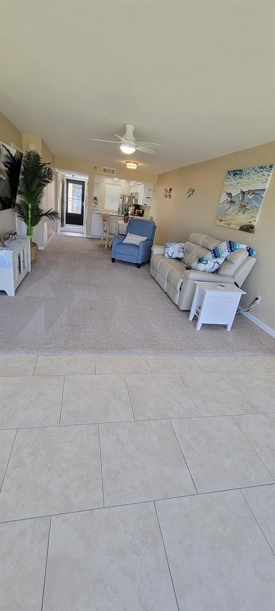 1551 Beach Rd Unit 412, Englewood, FL 34223 - unfurnished living room with carpet, ceiling fan, and tile patterned floors